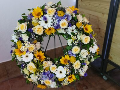 Trauerkranz mit Sonnenblumen und weiß-blauer Kombination