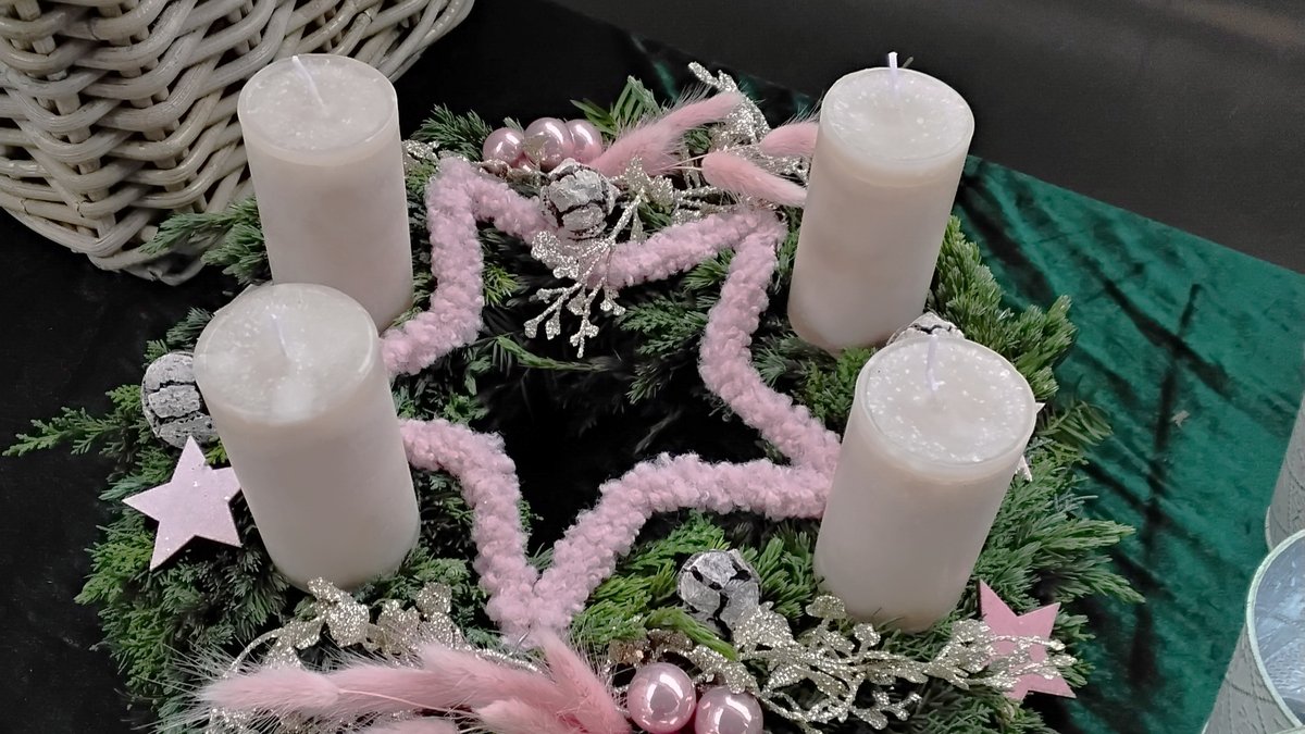 Adventskranz in Pastelltönen mit vier Kerzen und einem Stern