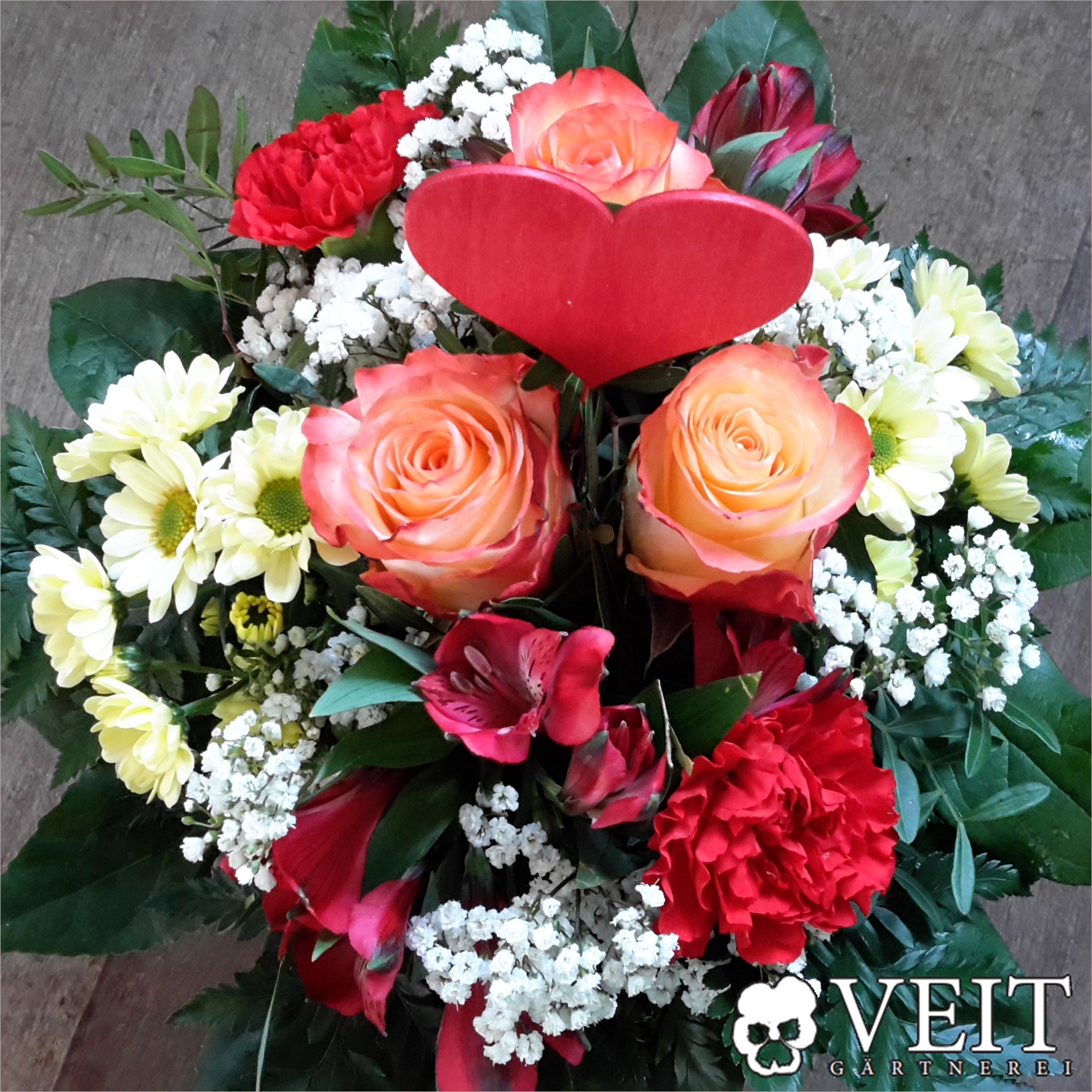 Blumenstrauß mit einem roten Holzherz für Valentinstag